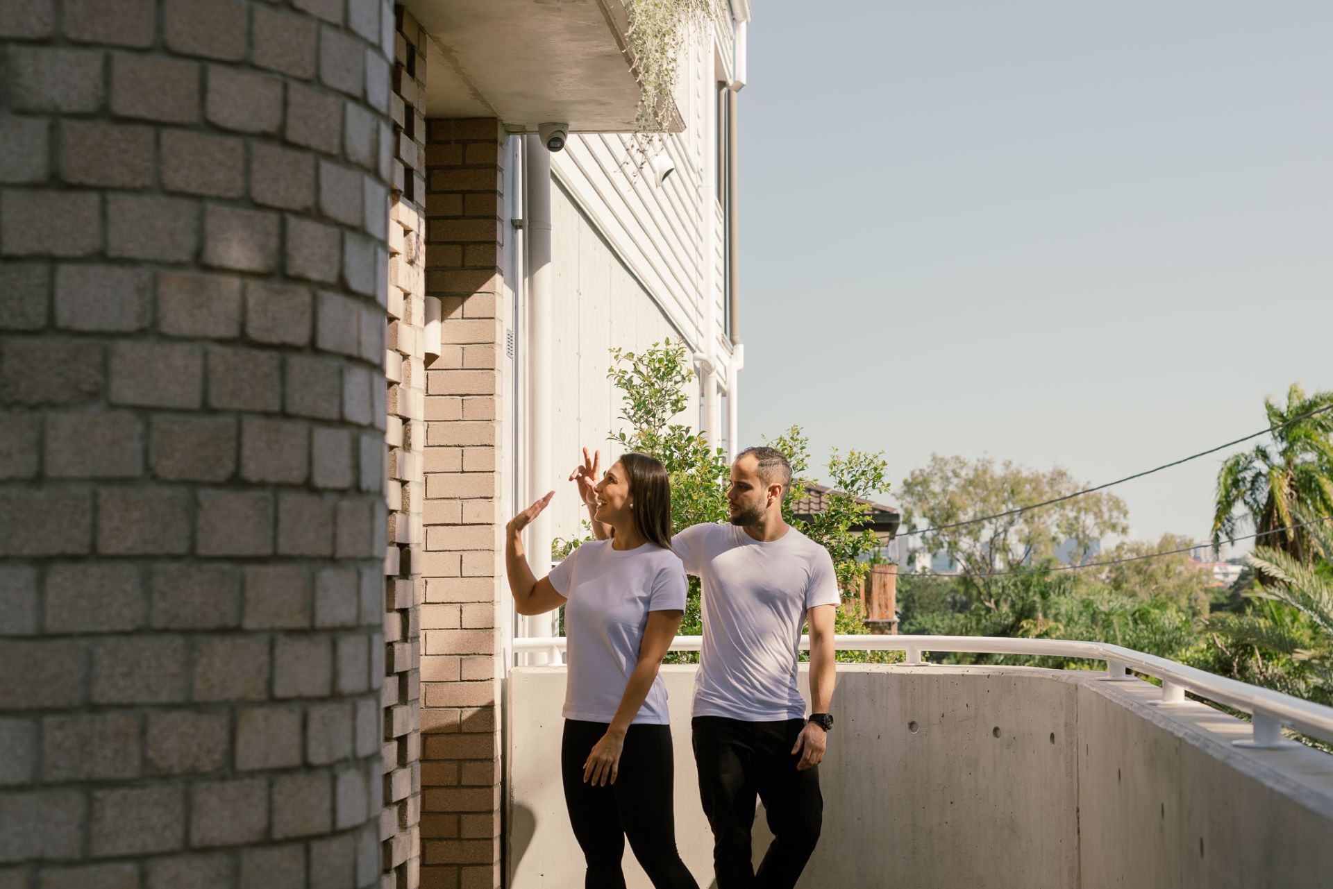 Couple waving goodbye outside a house
