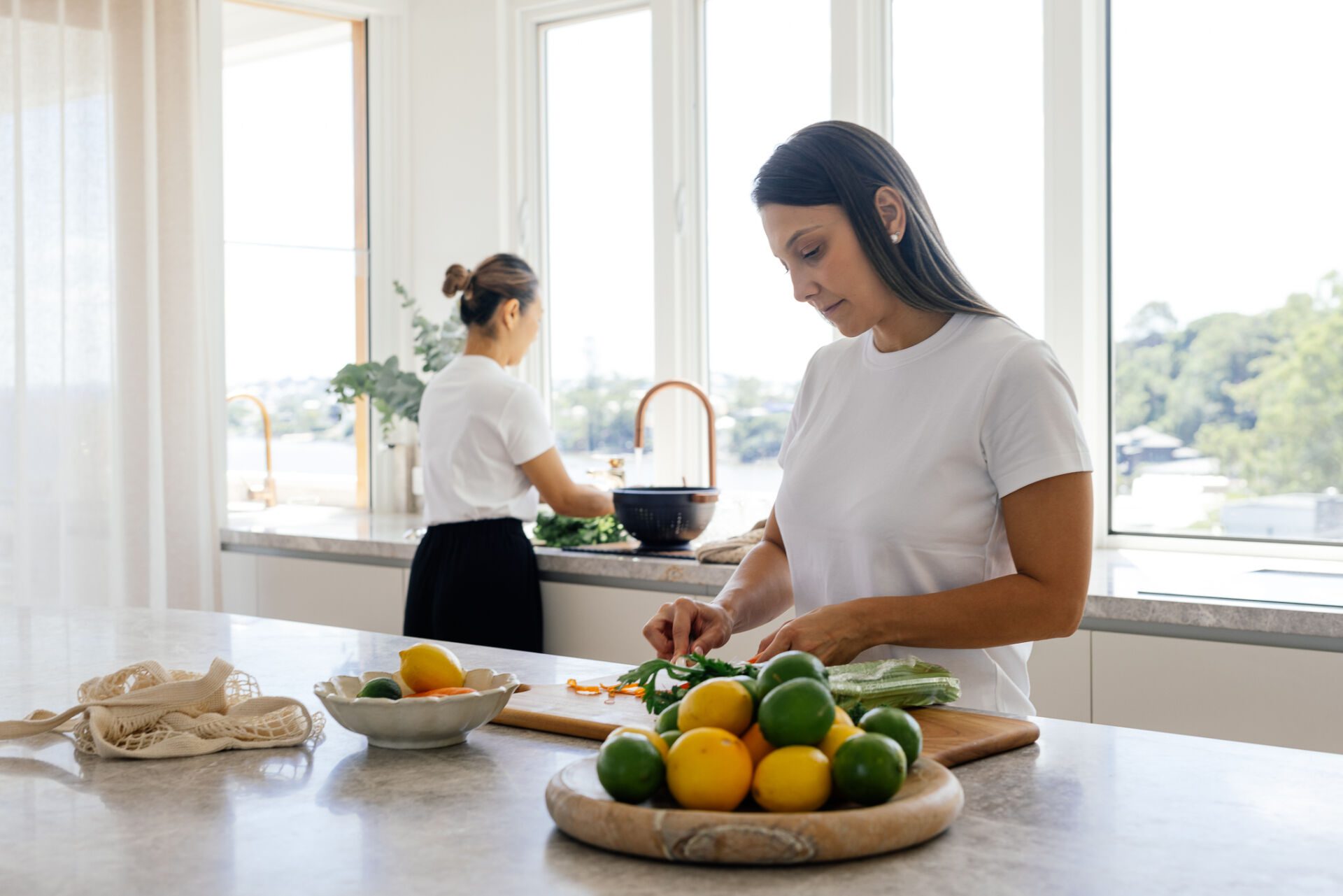 Two Family Clean Home Assistants preparing food and tidying up in a Sydney kitchen