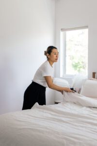 Brisbane house cleaner making a bed