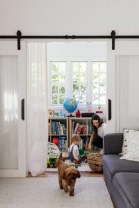 Family Clean home assistant playing with young child in playroom, giving parents a work-life balance break at home